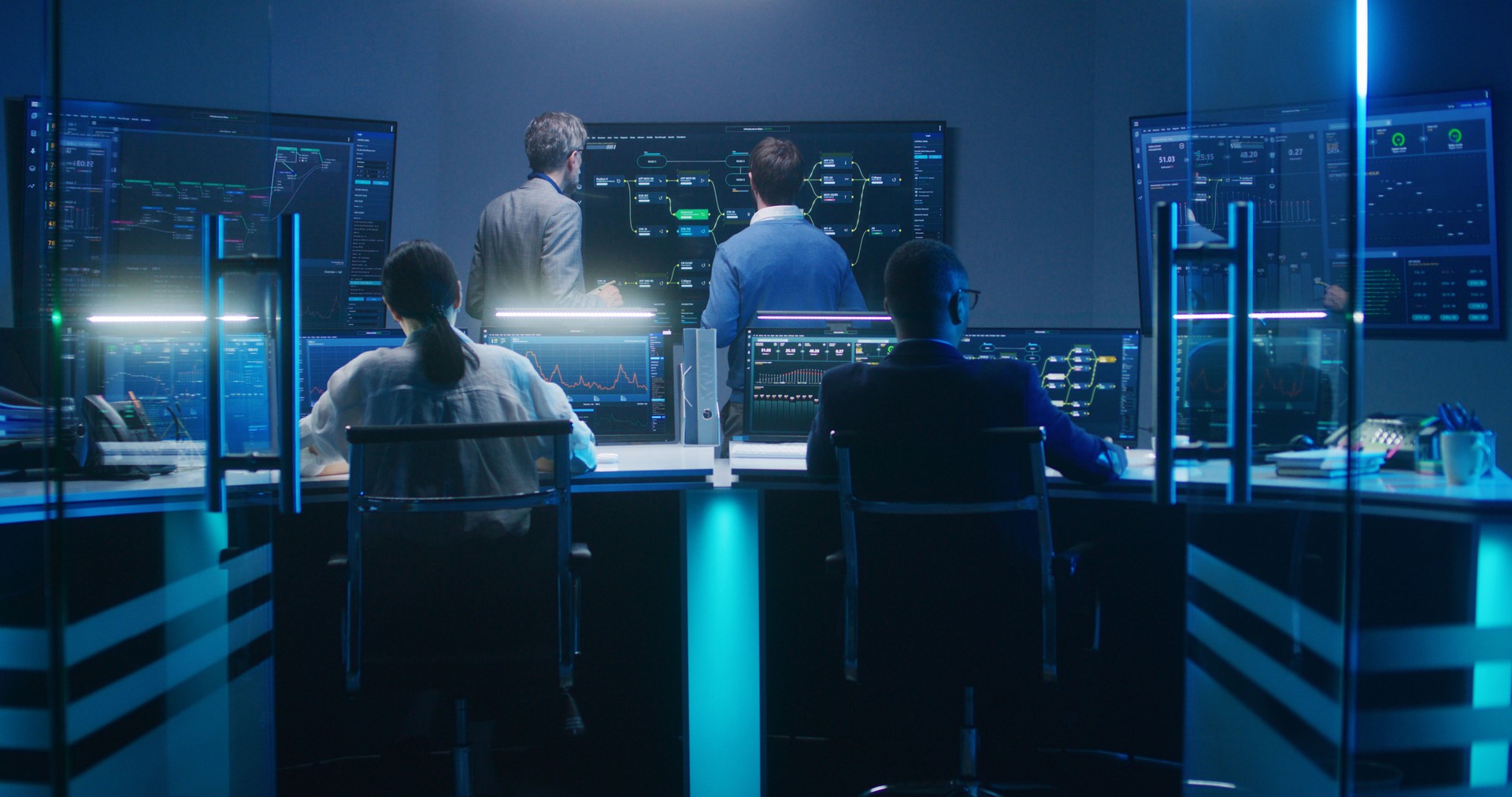Team of IT technical specialists and software programmers work in monitoring office