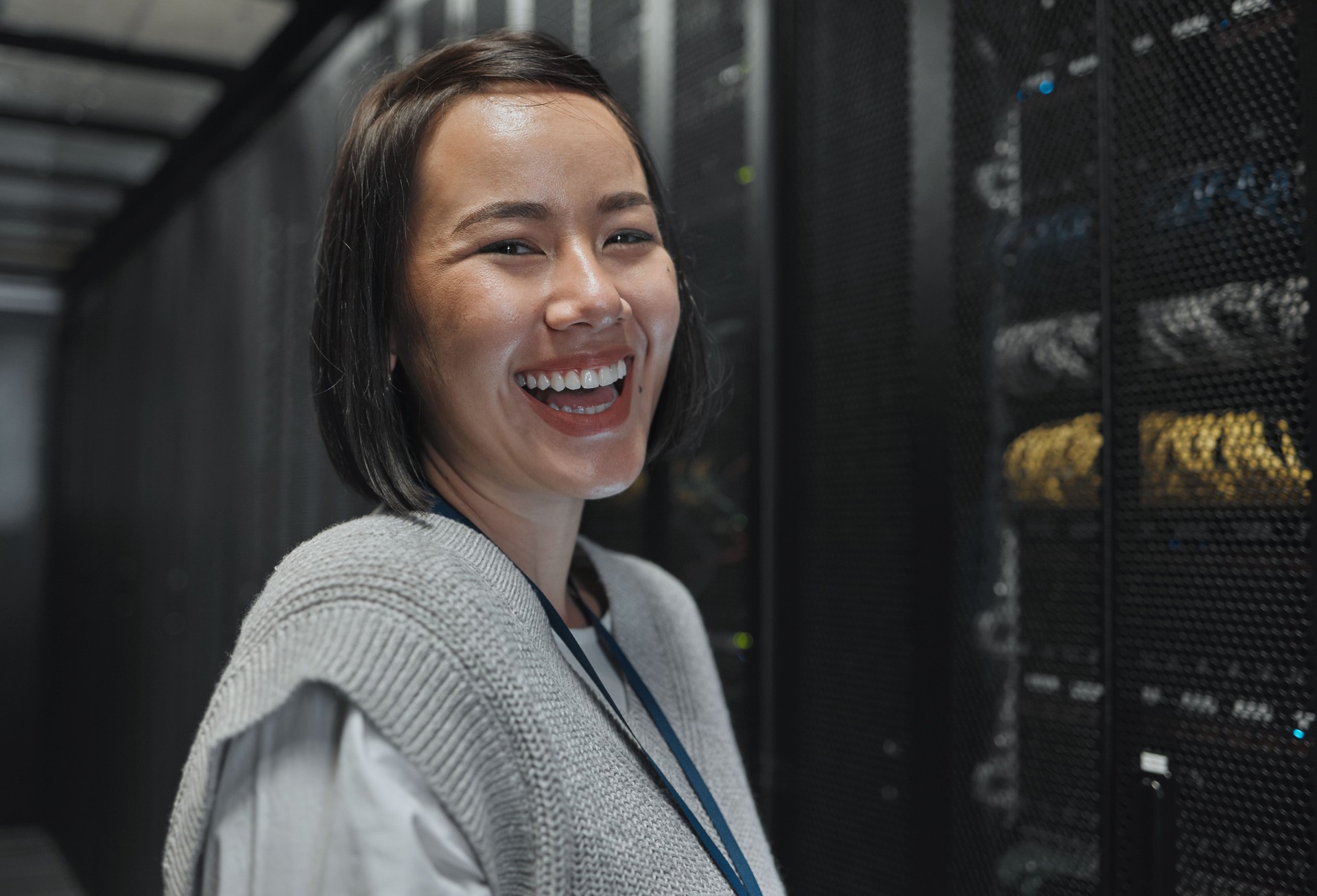 Woman, portrait and happy in server room with information technology, happy in job and datacenter with engineer. Asian female, funny and face with database, cybersecurity and system software upgrade